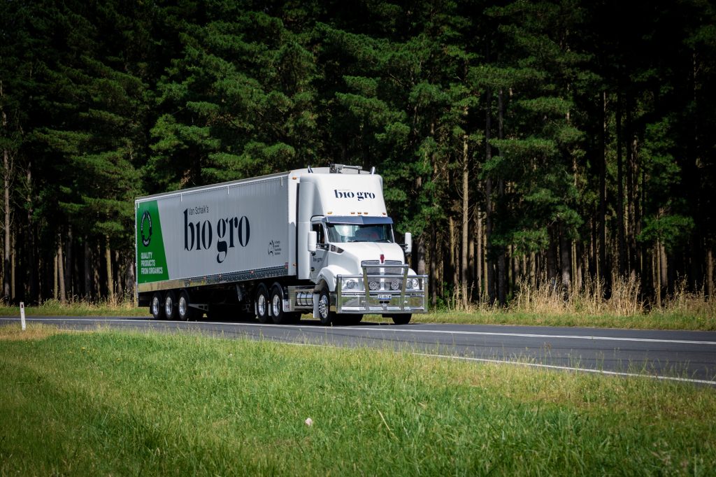 A truck driving along side forest